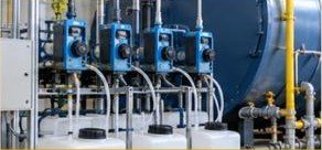 Industrial boiler with blue valves and feedwater pipework in a plant room