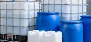 Blue chemical storage drums and IBC containers in a warehouse